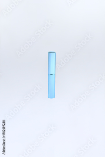 Minimalist lipstick cosmetic container blue cylindrical tube stands alone. Elegant cylindrical beauty product elegance beauty packaging with soft blue gradient finish and smooth reflective surface  