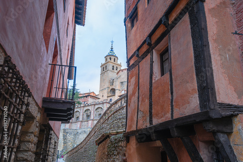 A narrow street with traditional medieval architecture and stone buildings in the historic town of Albarracin, Spain.
