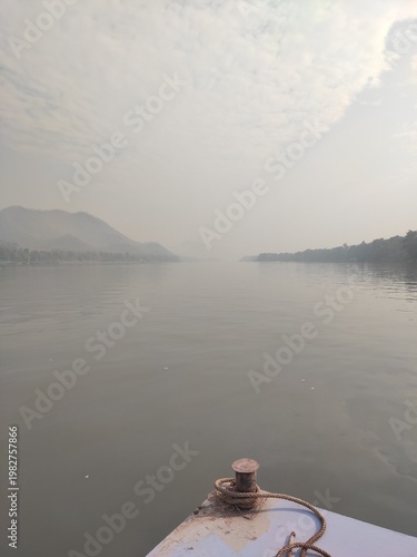 Traditional River Boat with Lao Flag and Mountain Landscape