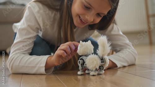 Young girl crouching to pet fluffy robotic dog toy on floor. Child activating pet robot with touch. Home play and interactive technology for kids companionship