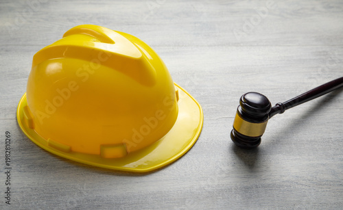 Foto Yellow construction helmet and judge gavel on the table.