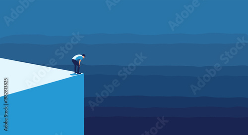 Contemplative man in a blue shirt stands on the edge of a high cliff while looking down into a deep blue abyss of uncertainty.