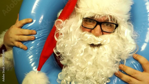 Santa Claus dreams of a seaside vacation with an inflatable ring