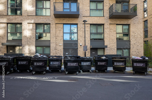 Row of trash bins outside apartment building
