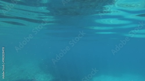 Underwater scene. Dark blue sea surface with rays of light