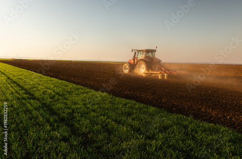Quadro su tela Farmer in tractor preparing land for sowing
