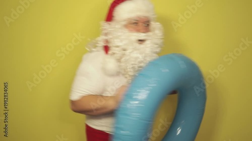 Santa Claus dreams of a seaside vacation with an inflatable ring
