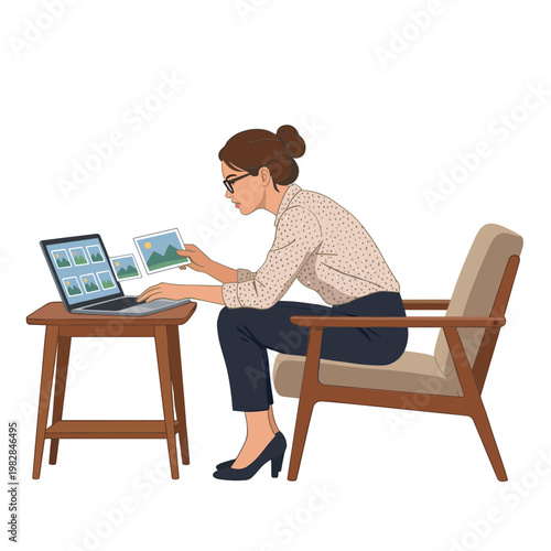 Woman sitting on chair examines photos on laptop and paper in office.