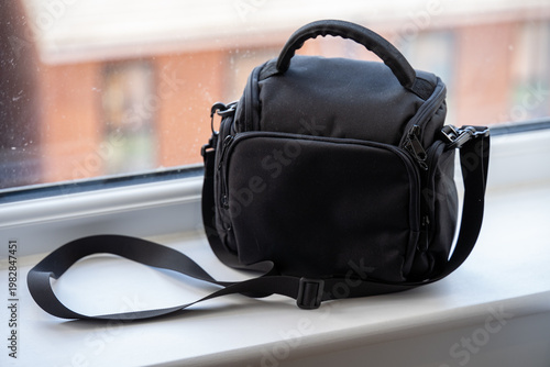Black camera bag on windowsill with bokeh background