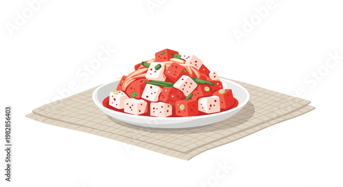 A generous portion of spicy red cubed radish kimchi garnished with green onions sits on a pristine white ceramic plate over a textured beige woven placemat.