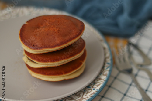 Japanese dorayaki pancakes. Golden fluffy pancakes cooking on a nonstick pan, close up homemade breakfast preparation, warm morning light, simple comfort food concept. cooking homemade breakfast