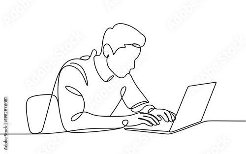 A man works on his laptop in a simple and minimalist workspace setting.