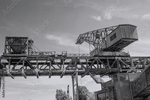 
old heavy-duty crane on an elevated track in a disused industrial area