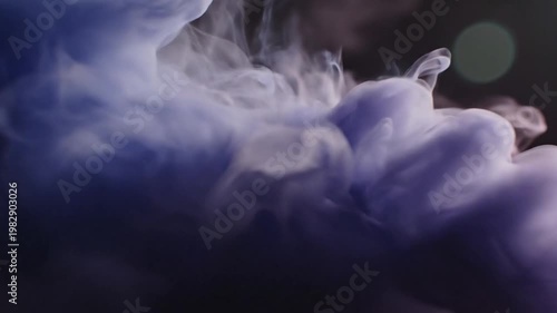 Vibrant dark blue and pink ink swirling on black background