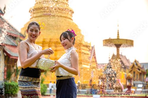 Canvas Print Thai women in traditional Northern Thai clothing holding water bowl splashing wa