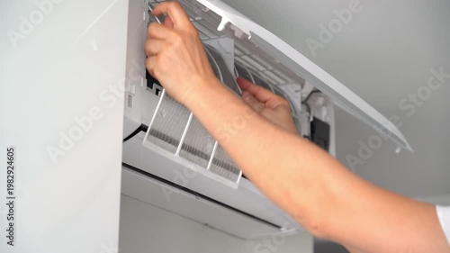 Close up of hands change cleaning filter in air conditioner. Air conditioning maintenance. Purification and repair of air conditioner