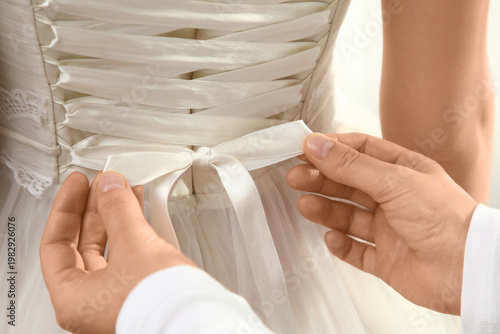 Woman tying bow on elegant ...