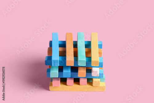 Colorful chalks on pink bac...
