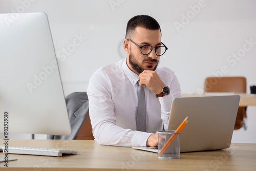 Thoughtful businessman usin...