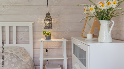 Panoramic Scandinavian bedroom interior background banner with cozy lighting and spring flowers