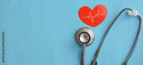 фотографія close up top view on red heart symbol and stethoscope on over blue background fo