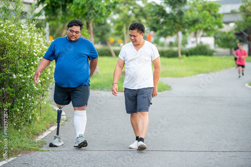 Fotografie Caregiver assisting and taking care of disabled man with prosthetic leg outdoors
