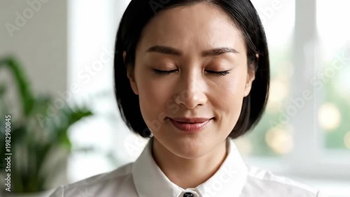 Calm Asian Businesswoman Practicing Mindfulness and Stress Relief in Office
