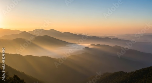 Golden sunrise illuminates misty mountain layers with dramatic sunbeams breaking through clouds over a serene valley landscape