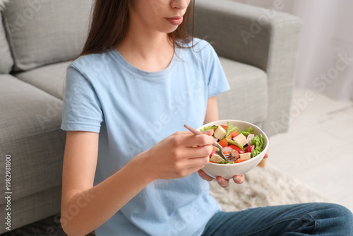 Young woman with bowl of sa...