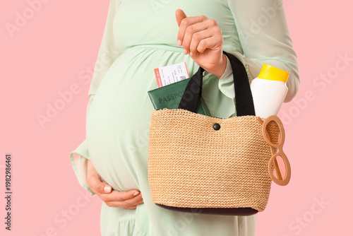 Young pregnant woman holdin...
