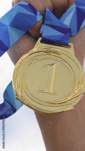 Golden Medal Glints Under Bright Sky. Closeup Of Shimmering Gold Medal With Reflective Sky Background