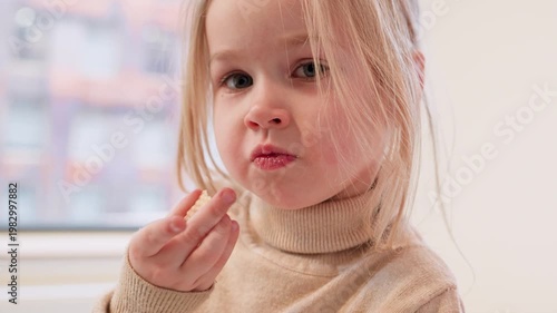 Child girl chews a cookie