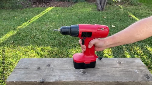 close up of hand pressing button to turn on cordless screwdriver tool activation moment power tool startup detail diy home repair and workshop equipment use