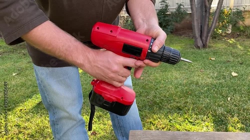 close up of hand pressing trigger on cordless screwdriver starting motor rotation power tool activation diy home repair equipment use workshop detail shot