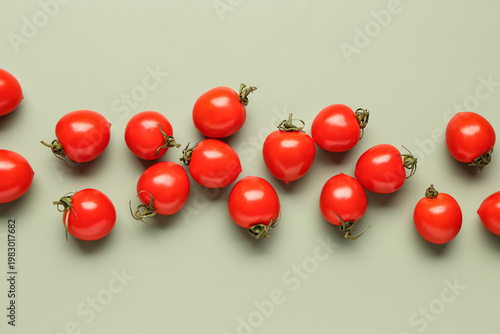 Many fresh cherry tomatoes on grey background