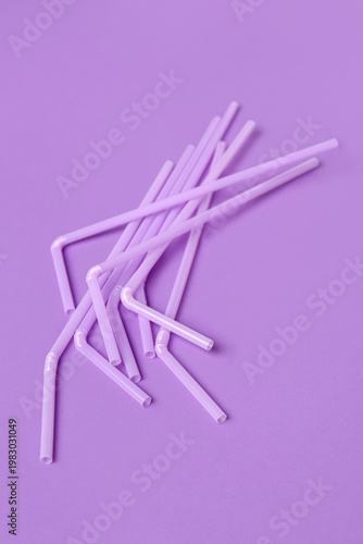 Lilac plastic straws on pur...