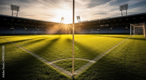 A moody and atmospheric view of an empty football stadium field during a golden sunset hour time