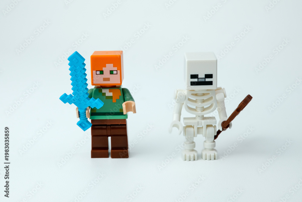 Naklejka premium Two Minecraft toy figures standing side by side, including a character with a blue sword and a skeleton figure with a brown weapon, on a white background on Apr 13, 2026 in Jakarta, Indonesia