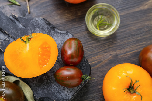 Board with different fresh tomatoes on wooden background