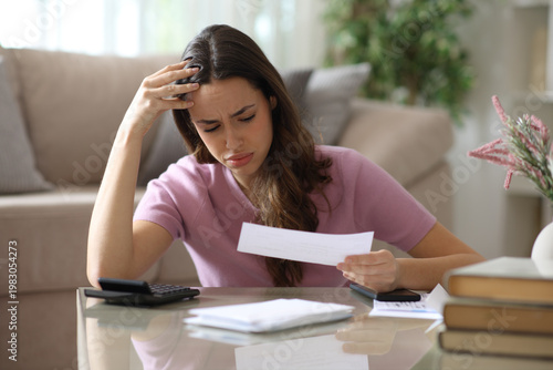 Schilderij op canvas Worried woman checking invoice and accounting at home