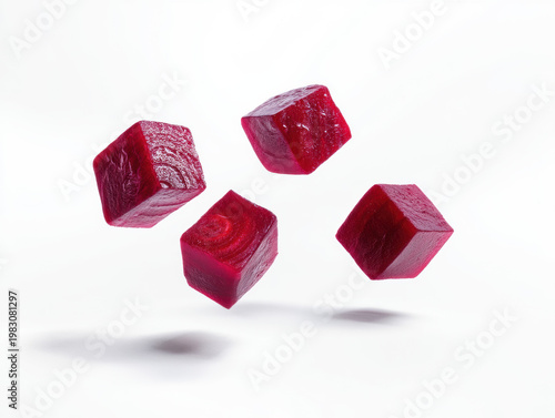 Three floating cubes of fresh raw beetroot isolated on white background