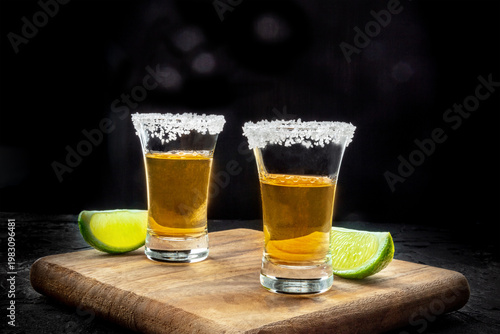 Wallpaper Mural Tequila shots with lime slices on a black slate background, side view with copy space Torontodigital.ca