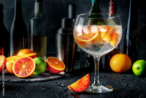Wallpaper Mural Gin Tonic cocktail in a copa glass at a bar, with oranges, side view on a dark background, with fresh fruit Torontodigital.ca