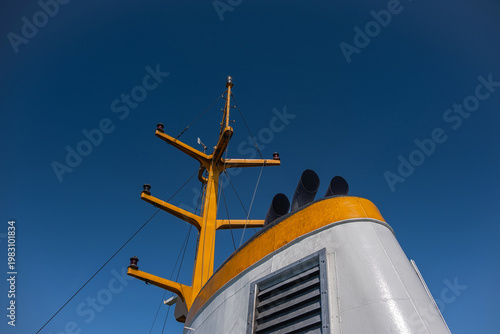 Ship Funnel and mast of passenger craft.  Blue sky background.
