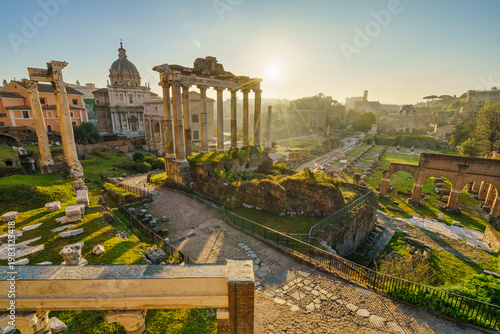 Ruins of Roman forum at sunrise with inscription "Senatus Populusque Romanus incendio consumptum restituit" - The Senate and People of Rome restored what had been consumed by fire. Rome. Italy