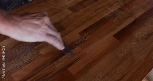 The laminated wood board is protected by tung oil, which was spread with a filler spatula