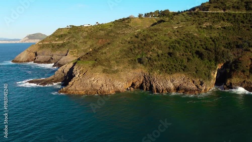 Aerial drone view of Cantabrian coastline with cliffs, green hills and ocean waves. Scenic coastal landscape in northern Spain, travel destination and nature scenery. High quality 4k footage