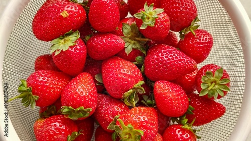 Fresh ripe strawberries in colander, top view of organic red strawberries, healthy summer fruit, natural food background, washed strawberries ready to eat, vibrant fresh berries texture