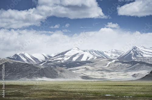Mountain landscape with a view of a rocky ridge with snow and glaciers in the highlands of Tajikistan in the Pamirs. A panorama of the Tien Shan Mountains for background