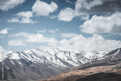 Mountain landscape with a view of a rocky ridge with snow and glaciers in the highlands of Tajikistan in the Pamirs. A panorama of the Tien Shan Mountains for background